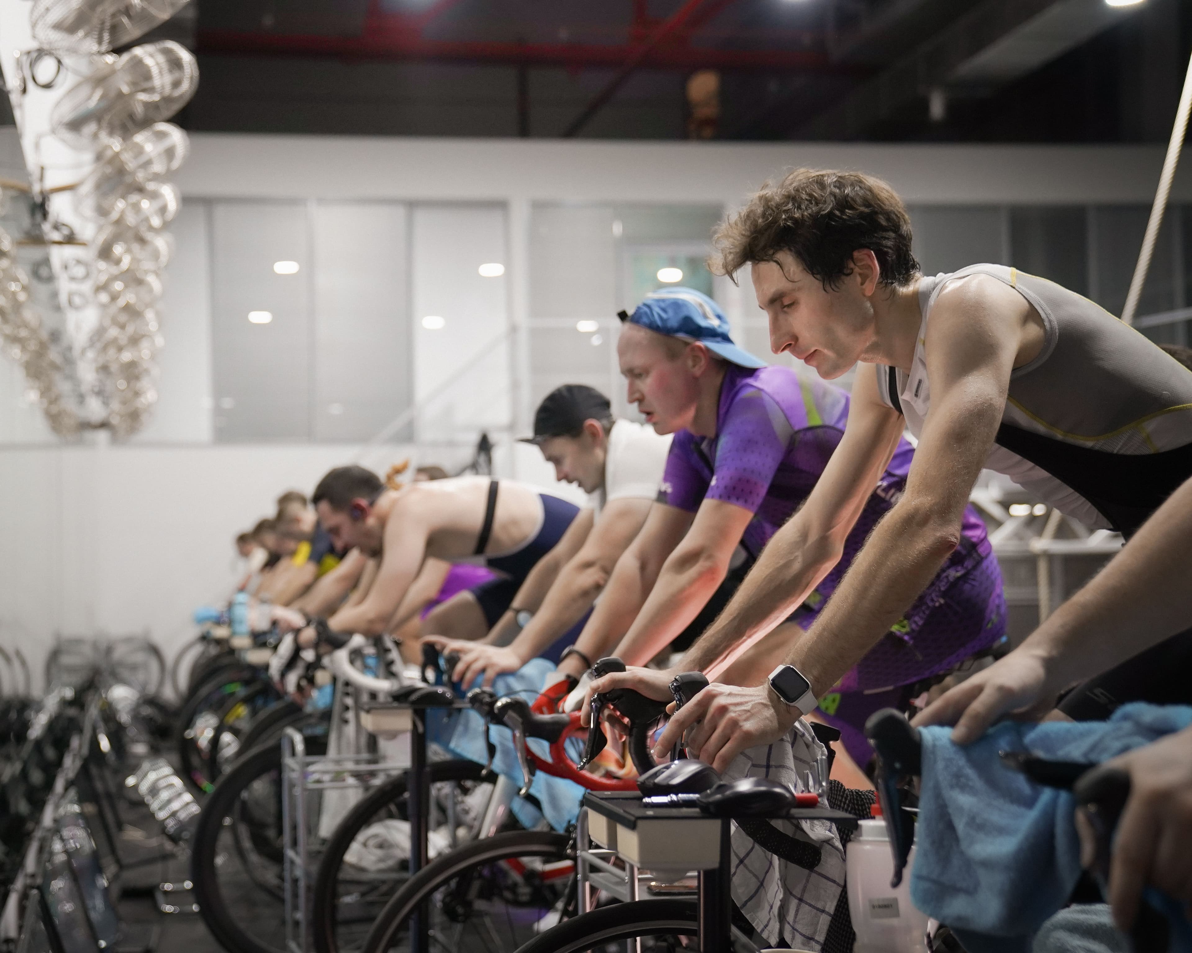 A group of people taking part in an indoor cycling class, representing group exercise and shared motivation
